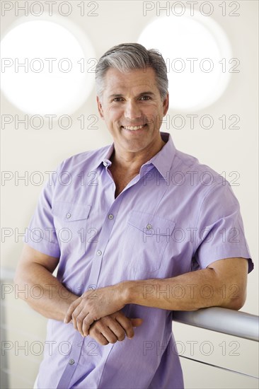 Caucasian man leaning on banister