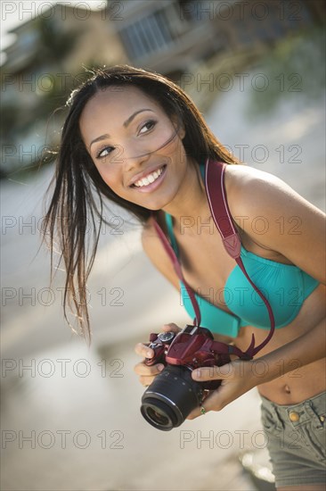 Hispanic woman taking pictures outdoors
