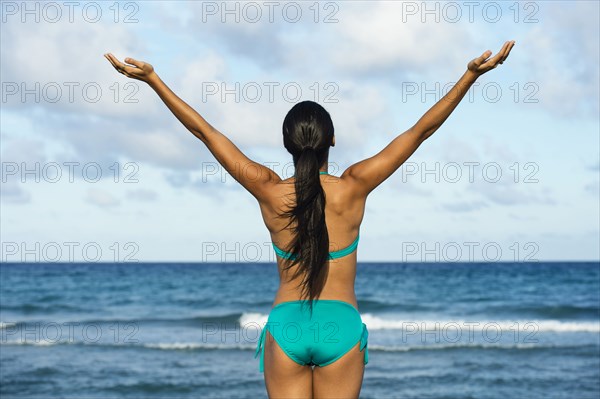 Hispanic woman wearing bikini on beach