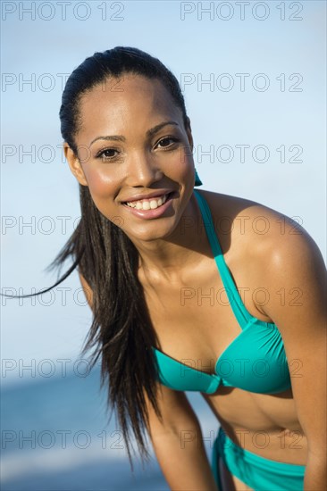 Hispanic woman wearing bikini on beach