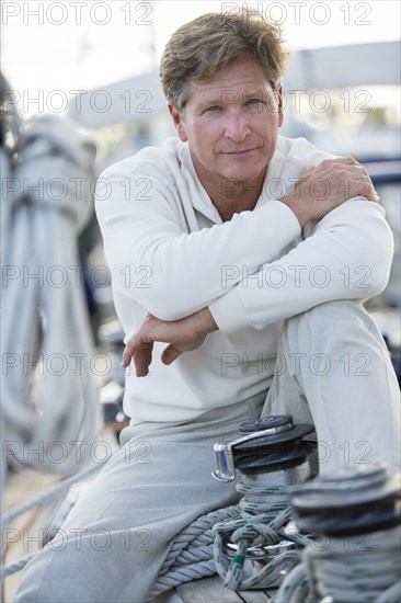 Caucasian man sitting on sailboat