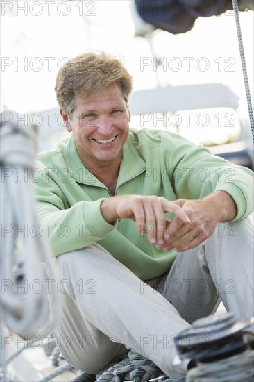 Caucasian man sitting on sailboat