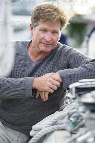 Caucasian man sitting on sailboat