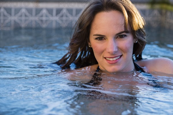 Hispanic woman swimming in pool