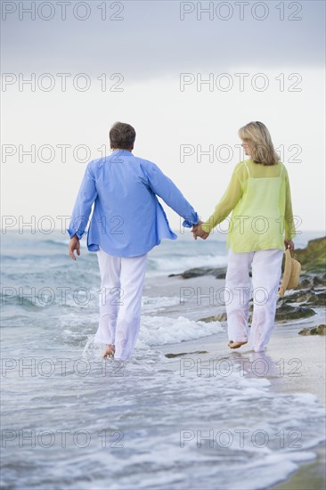 Caucasian couple walking on beach