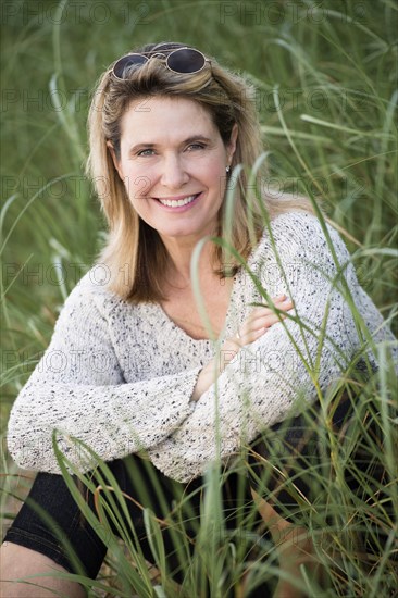 Caucasian woman sitting in tall grass