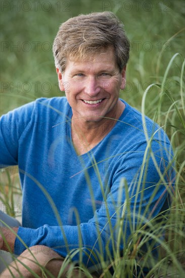 Caucasian man sitting in tall grass