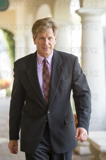 Caucasian businessman walking in colonnade