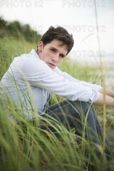 Hispanic man sitting in tall grass