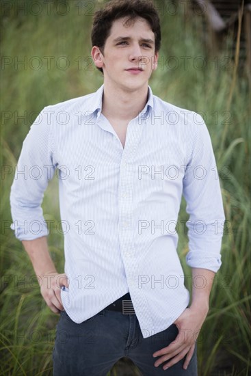 Hispanic man standing in tall grass