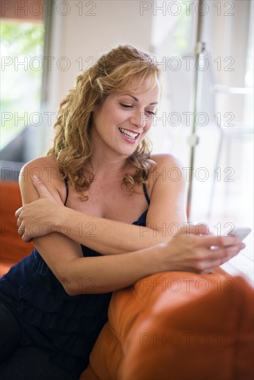 Caucasian woman using cell phone on sofa