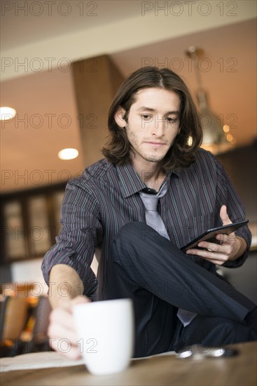 Caucasian businessman reaching for cup of coffee