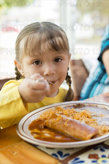 Hispanic girl eating dinner at table