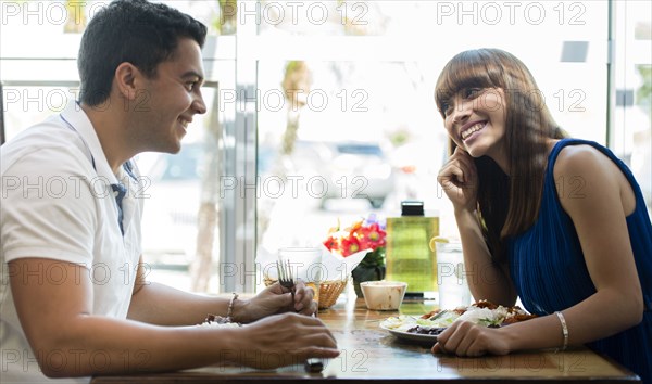 Hispanic couple eating together at cafe