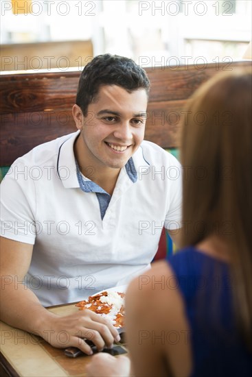 Hispanic couple eating together at cafe