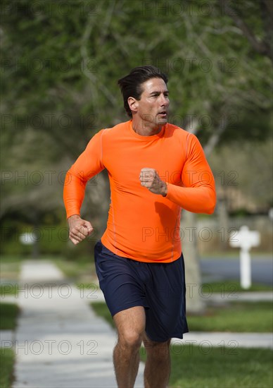 Caucasian man jogging on suburban street