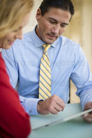 Caucasian business people using digital tablet in meeting