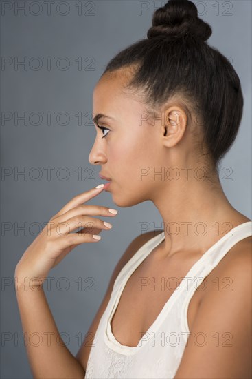 Profile of mixed race woman touching her lip