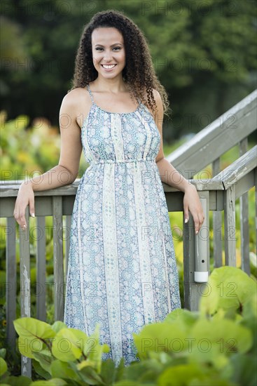 Mixed race woman leaning on wooden banister