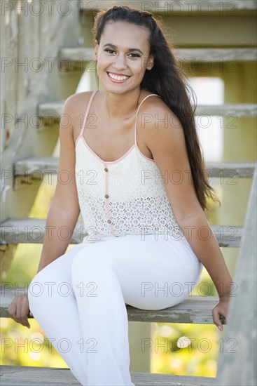 Mixed race woman sitting on wooden steps