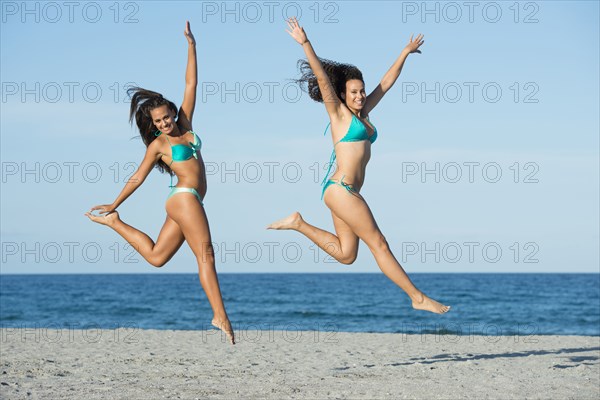 Women jumping for joy on beach