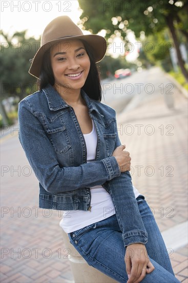 Black woman sitting on pillar