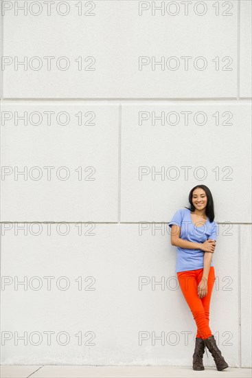 Black woman smiling near concrete wall