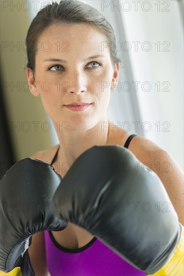 Caucasian woman with boxing gloves raised