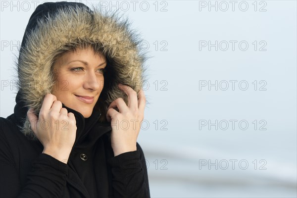 Caucasian woman wearing coat with fur hood outdoors