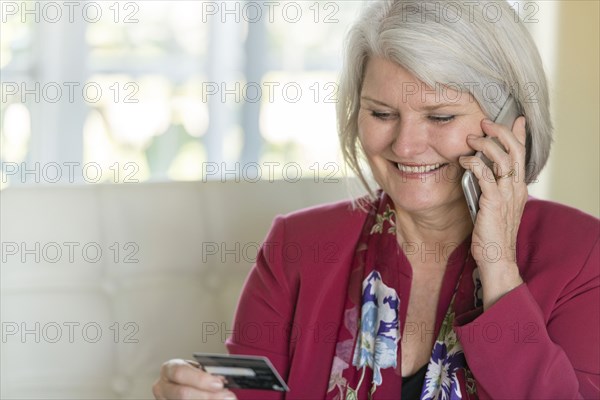 Caucasian older woman shopping with cell phone