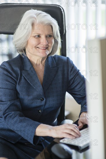 Caucasian businesswoman working at computer