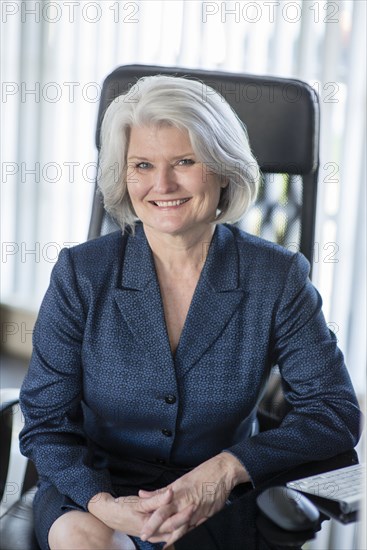 Caucasian businesswoman smiling at desk