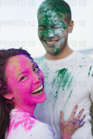 Caucasian couple splattered with paint powder