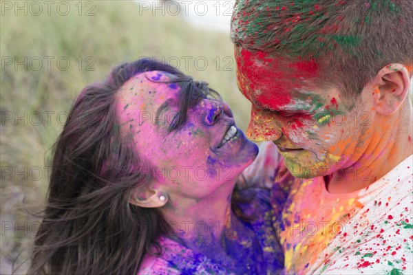 Caucasian couple splattered with paint powder