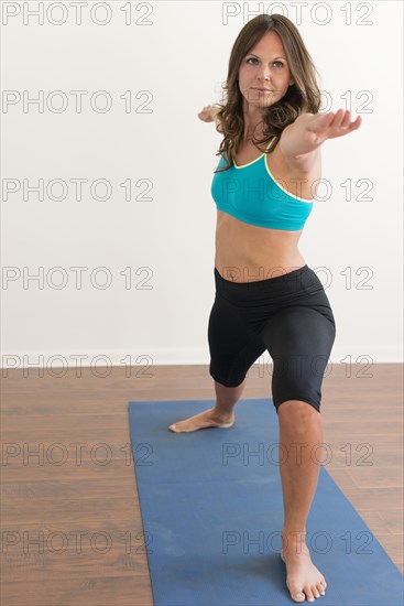 Caucasian woman practicing yoga with arms outstretched