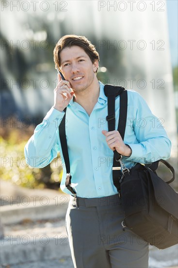 Hispanic businessman talking on cell phone outdoors