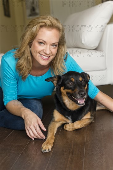 Caucasian woman playing with dog in bedroom