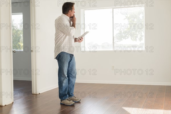 Caucasian man using digital tablet in empty room