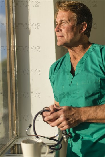 Caucasian nurse looking out window