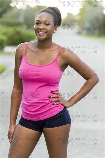 Mixed race woman smiling on suburban road