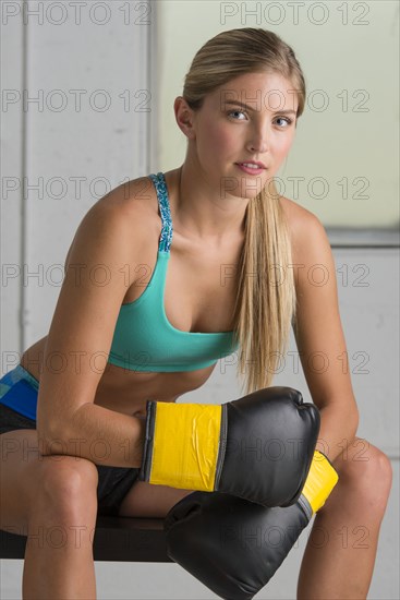 Caucasian boxer wearing boxing gloves in gymnasium