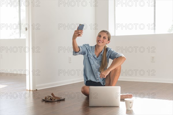 Caucasian woman taking selfie in empty room