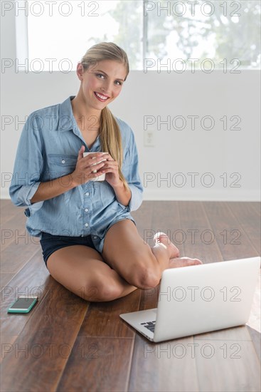 Caucasian woman using laptop in empty room