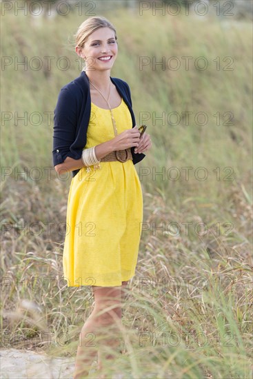 Caucasian woman standing in tall grass field
