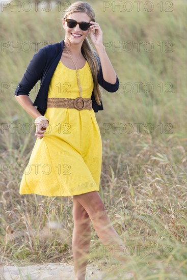 Caucasian woman walking in tall grass field