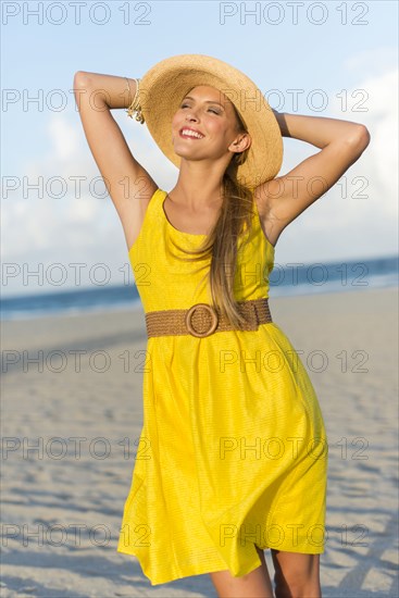 Caucasian woman wearing sun hat on beach