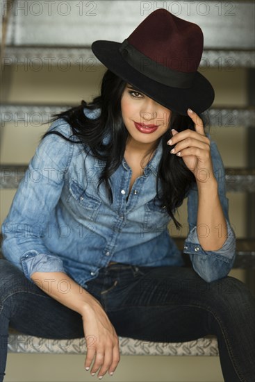 Glamorous Hispanic woman sitting on staircase