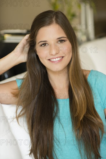 Caucasian woman with long hair sitting on sofa