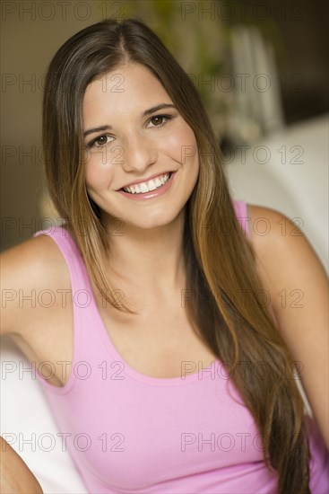 Caucasian woman with long hair sitting on sofa