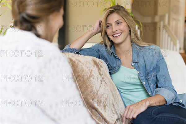 Caucasian women talking on sofa